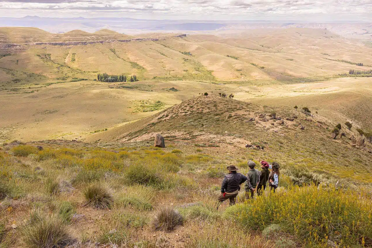 Four hikers look out over the view from the mountain at Tipiliuke lodge in Patagonia.