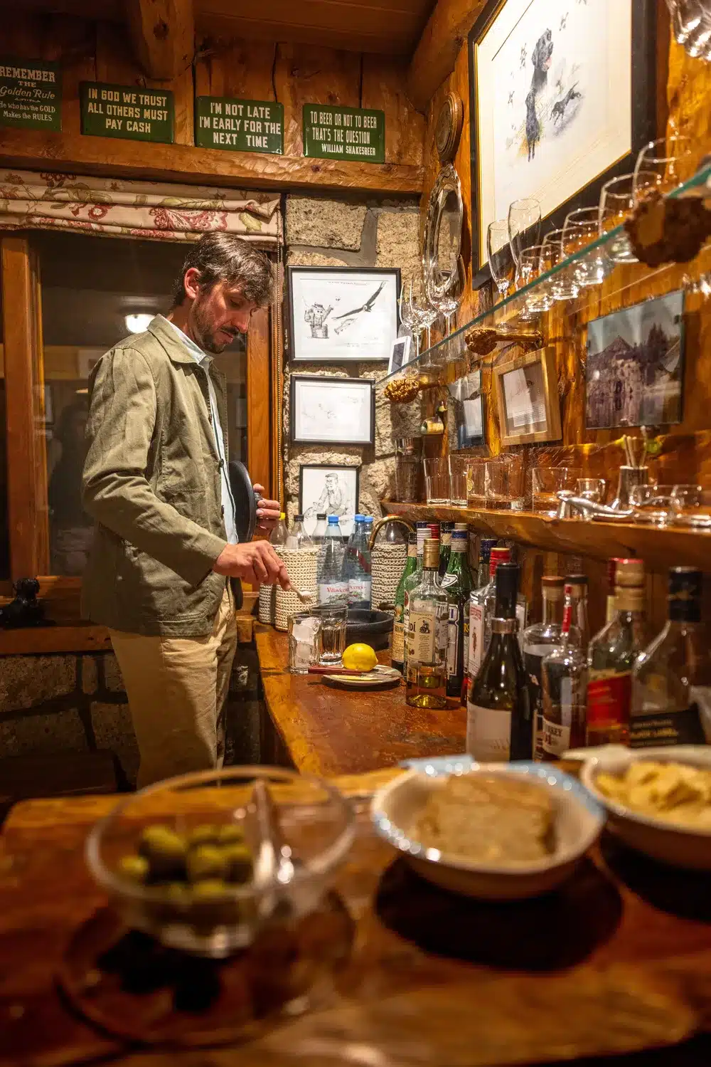 a man prepares a gin and tonic in the bar at Arroyo Verde lodge behind a table laden with snacks